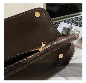 Close-up of premium dark brown leather bag with refined gold hardware and stitching detail