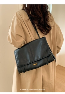 Rückansicht eines Modells mit schwarzer Retro-Ledertasche und goldenen Metallbeschlägen