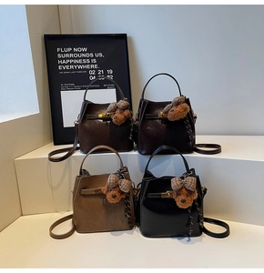 Dettaglio di quattro borse a secchiello nei colori caffè, caramello, marrone e nero con orsetti