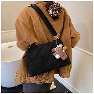 Quilted black suede tote bag detail with cute brown teddy bear pendant and gold hardware