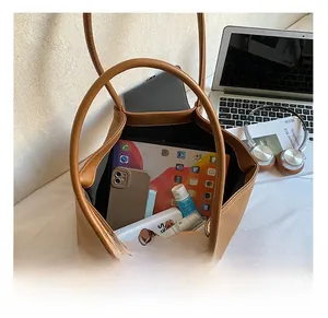 Detailed interior of a brown leather shoulder bag showing its large storage capacity