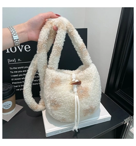 Close-up of plush faux fur bucket bag with floral pattern and wooden toggle closure