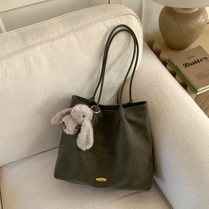 Deep green large tote bag in matte leather texture with golden buckle and rabbit charm