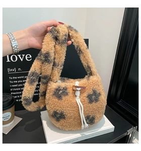 Detail of plush lamb wool bucket bag showing drawstring closure and horn button buckle