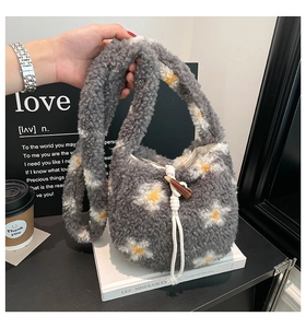Detail of grey plush bucket bag with daisy patterns and wooden toggle closure