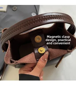Dettaglio della borsa a secchiello marrone vintage con chiusura magnetica e trama in pelle