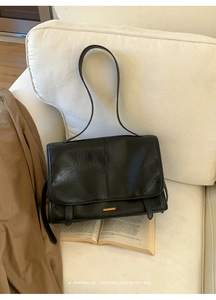 Detailansicht der schwarzen Retro-Ledertasche mit Plissee-Struktur und goldener Metalleiste