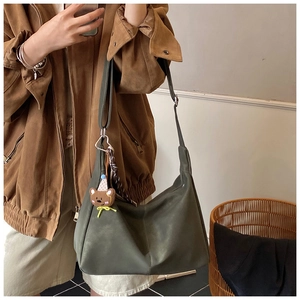 Dettaglio borsa tote verde oliva in pelle PU con ciondolo a orsetto e foulard di seta