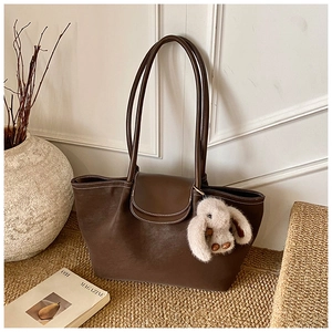 Detail of coffee tote bag with white contrast stitching and plush bunny pendant detail