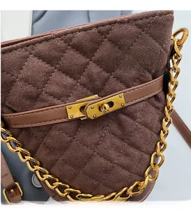 Gros plan sur un sac seau marron matelassé avec chaîne dorée et fermoir pivotant