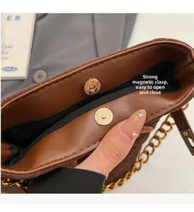 Détail du sac à main marron montrant le fermoir magnétique puissant et la chaîne dorée