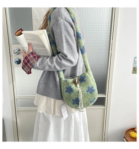 Detail of plush lamb wool bucket bag with blue floral patterns and wooden button closure