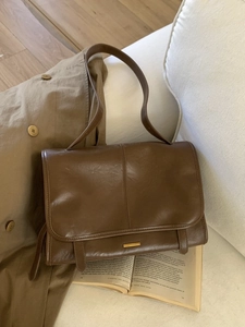 Vintage braune Tragetasche aus Leder mit langem Riemen in warmer Lifestyle-Umgebung