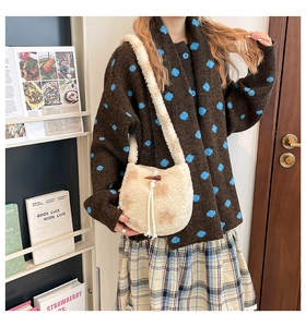 Détail du sac seau en peluche beige avec boucle en corne et cordon de serrage doux