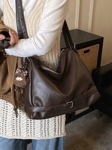 Large dark brown leather tote bag with decorative buckle and leopard print bow charm