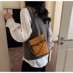 Détail du sac seau matelassé jaune gingembre avec chaîne dorée et bandoulière