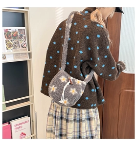 Détail du sac seau en peluche grise avec motifs floraux et boucle en corne marron