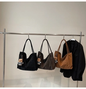 Three vintage tote bags in black and brown hanging with cute bear charms on metal hooks