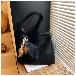 Dettaglio ravvicinato di una borsa hobo in pelle nera opaca con ciondoli graziosi