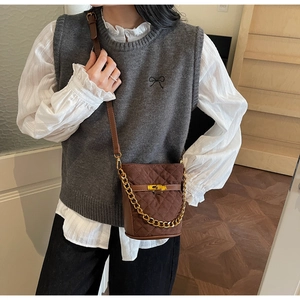 Brown quilted suede bucket bag with gold chain strap and metal turn-lock detail