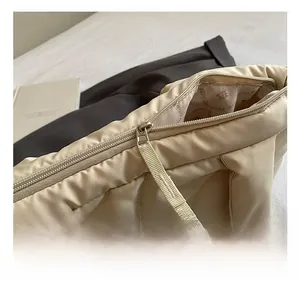 Macro shot of silver metal zipper and wave quilted texture on beige tote bag