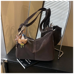 Dettaglio della borsa hobo in ecopelle marrone scuro con ciondolo a forma di orso
