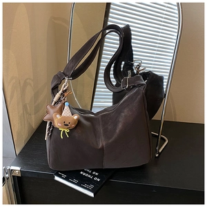 Dettaglio della borsa tote in ecopelle marrone scuro con ciondolo a forma di orso