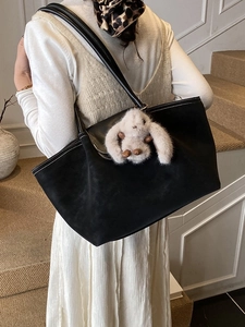 Minimalist large black tote bag with plush rabbit charm and elegant white contrast stitching