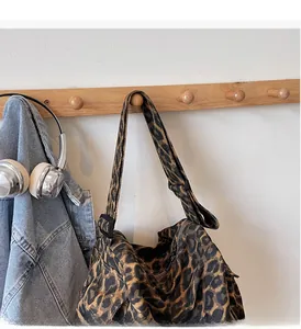 Detail of leopard print canvas tote bag with adjustable black straps and zipper closure