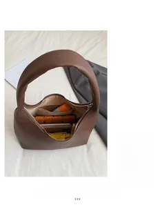 Detail view of brown lychee grain leather handbag with interior zipper pocket and slots