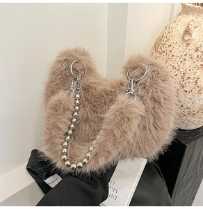 Close-up of light brown plush handbag featuring silver beaded chain strap and fuzzy texture