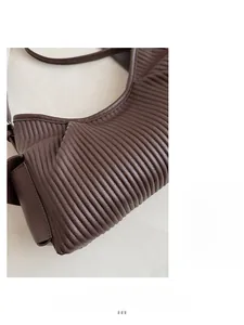 Detail of dark brown tote bag showing pleated texture and soft faux leather material