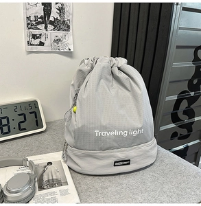 Borsa grigia a coulisse con scritta Traveling light e scomparto con cerniera
