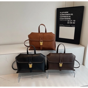 Three retro crossbody bags in brown, black, and coffee leather with gold metal buckles