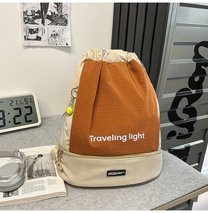 Dettaglio della borsa sportiva con coulisse in arancione e beige in nylon impermeabile
