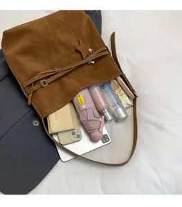Détail du sac fourre-tout en daim marron avec pendentif étoile et intérieur spacieux