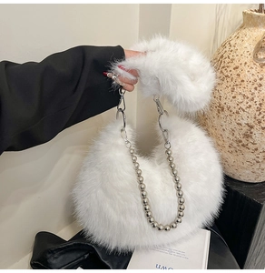 Detail of white faux fur handbag featuring silver bead chain and soft plush texture