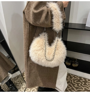 Detail of beige plush crescent bag featuring silver beaded chain and fuzzy strap