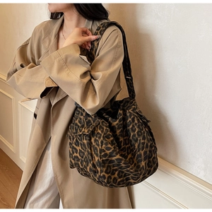 Detail of leopard print canvas crossbody bag featuring side flap pockets and large capacity