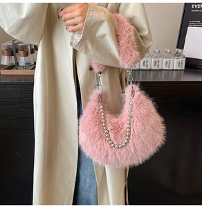 Detail of pink faux fur crescent bag with decorative silver pearl chain and ring