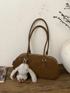 Brown suede Boston shoulder bag with long handles and a white rabbit plush charm