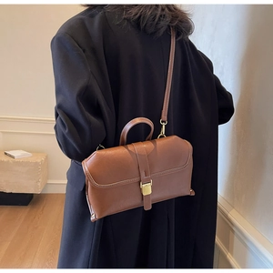 Minimalistische braune Vintage-Umhängetasche aus Leder getragen von einem Modell