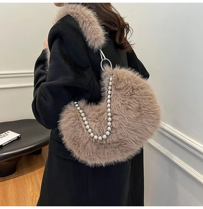 Detail of khaki faux fur crescent bag featuring elegant pearl chain and plush shoulder strap