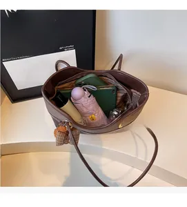 Spacious interior of brown leather tote bag showing umbrella, tablet and phone