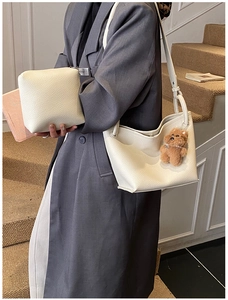 Detail of off-white lychee grain leather tote and small pouch with brown bear charm