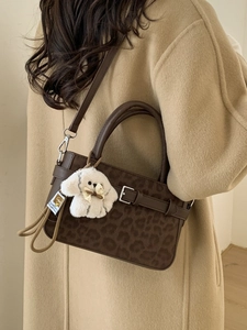 Borsa leopardata marrone con ciondolo di peluche abbinata a un cappotto beige autunnale