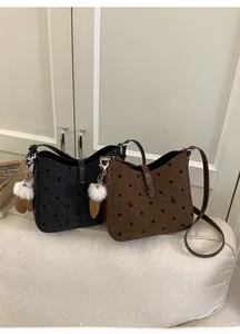 Detail view of vintage polka dot bucket bags in black and brown with plush glove charms