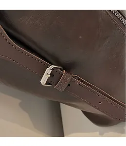Detailed macro view of dark brown leather texture with silver metal buckle and precise stitching