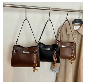 Close-up of vintage suede tote bags in coffee, black and brown with metal buckles