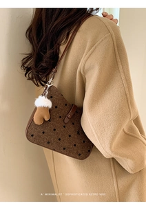 Detail of retro polka dot brown tweed underarm bag with cute glove charm pendant